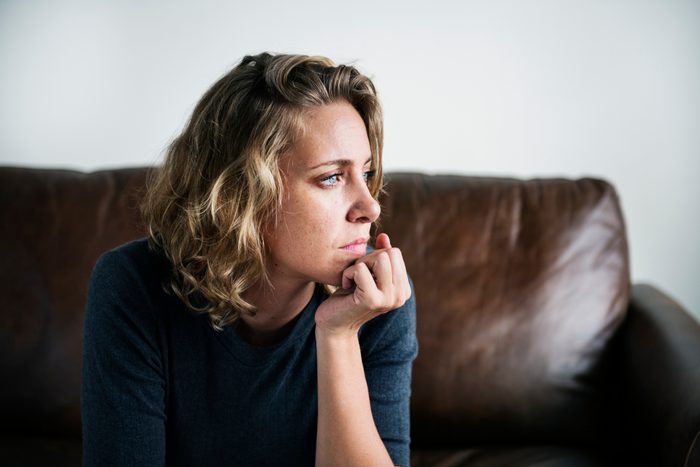 woman sitting on sofa sad