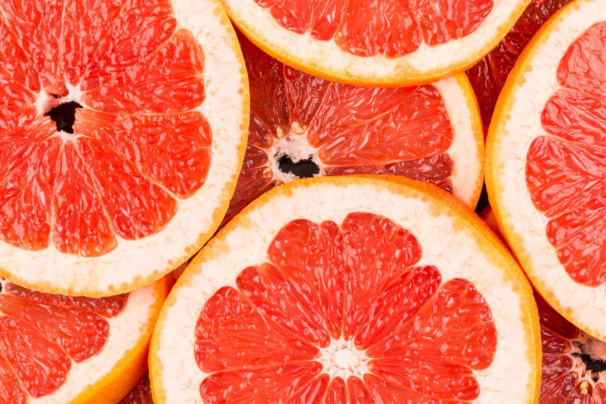 Abstract Red Background With Citrus Fruit Of Grapefruit Slices